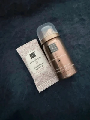 Rituals bodylotion mousse & tvål - Set med Rituals The Ritual of Hammam body lotion mousse (30 ml) och The Ritual of Sakura shampoo & body bar. Bodylotionen kommer i en kopparfärgad flaska och tvålen är inslagen i mönstrat papper. Doft av lotus, arganolja, körsbärsblom och rismjölk.