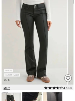 Svarta bootcut jeans från Nelly - Snygga svarta bootcut jeans från Nelly med hög midja och pressveck framtill. Jeansen har klassisk femficksdesign, två knappar i midjan och är tillverkade i ett stretchigt material för skön passform. Perfekta för en trendig och avslappnad look.
