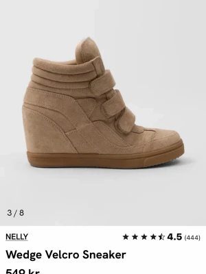 Beige wedge sneakers från Nelly - Snygga beige sneakers med kilklack och tre breda kardborreband från Nelly. Skorna är tillverkade i mockaimitation och har en hög siluett som ger extra höjd. Perfekta för dig som vill ha både stil och komfort i ett par sneakers. Använt ett par gånger bara 