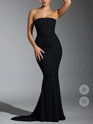 Svart glittrig axelbandslös långklänning - Säljer en superfin svart festklänning/balklänning i perfekt skick från Oh Polly! Använd endast 1 gång, så den är fortfarande som ny 🤍  Klänningen är väldigt elegant och passar perfekt till fest, bal eller andra speciella tillfällen. Säljs endast eftersom den tyvärr blivit för liten för mig. Klänningen har inga defekter.  ✔️ Nyskick ✔️ Endast använd en gång  Hör gärna av dig vid frågor eller om du vill ha fler bilder! ✨