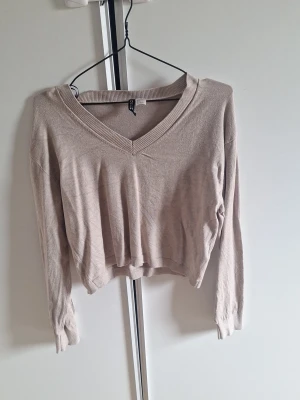 Beige V-ringad tröja från H&M - En stilren beige tröja från H&M med V-ringning strl S