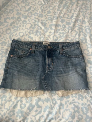 Blå jeanskjol från Monki - Säljer en blå jeanskjol från Monki. Kort modell med fransig kant som ger en snygg, enkel att matcha och passar perfekt till både vardag och sommar☀️💐. 