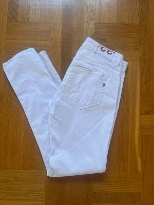 Vita Dondup Jeans - Snygga vita jeans från Dondup. Storlek 33. I fint skick. Endast en fläck bak på högerbenet (Bild 6). Skick 8/10. Hör av er vid minsta fundering!