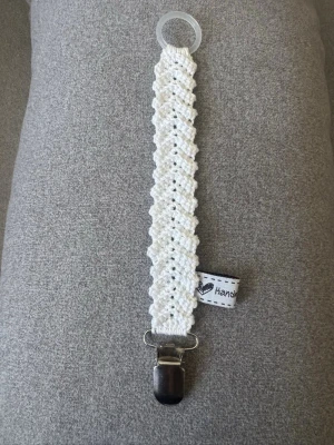 Virkad napphållare  - Virkad, vit napphållare, virkad av mig i 100% bomullsgarn med metallclips och silikonring.  Mönsterskapare: animo.design 