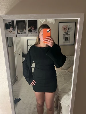 Svart kort klänning med vida ärmar - Säljer den här jätte snygga klänningen som har används en gång från Nelly. 