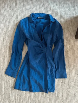 Blå skjortklänning - Blå kort skjortklänning från Zara. Väldigt kort på mig som är 178cm. Använd 1-2 gånger därmed superfint skick!💙