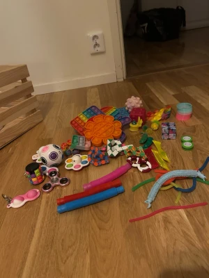 Stort paket med fidget/stressleksaker - Säljer ett stort paket med olika fidget- och pop it-leksaker i flera färger och former, bland annat regnbågsfärgade pop its, kuber, bollar, rör och snurror. Allt på bilden ingår. 