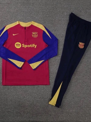 FC Barcelona träningsset Nike - Säljer ett FC Barcelona träningsset från Nike med långärmad röd tröja, gula och blå detaljer samt klubbmärke och Spotify-logga. Matchande mörkblå byxor med gula inslag och klubbmärke. Perfekt för fotbollsträning eller sportiga dagar.