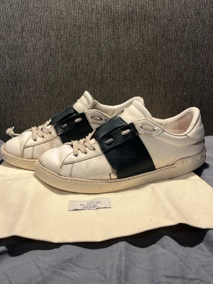 Valentino open mörkblå  - Säljer ett par valentino open som är vita och mörkblåa. Skorna är i helt okej skick. Dem har används men har fortfarande mycket kvar och ge. Skorna är äkta. De är köpte här på Plick sommaren 2024. Säljer eftersom de blev försmå för ett bra tag sedan. Stolek 41 och lite stora i storleken.