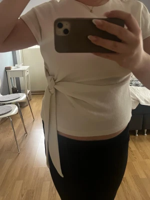 Vit topp med knyt i midjan - Säljer en stilren vit topp med korta ärmar och snygg knytning i midjan. Från Zara och använd nästan aldrig💗