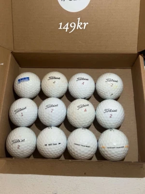 Titleist mix 12-pack  - Säljer ett set med 12 vita golfbollar från Titleist, flera med märkningarna 2 och 4. Bollarna är runda och tillverkade i slitstarkt material, perfekta för golfbanan. Levereras i kartong.