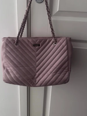 Väska  - Säljer jättefin handväska från Don Donna, väldigt fint skick. Ända defekten är att den har rostat lite i mitten av kedjorna, se tredje bilden. Skicka prisförslag💞