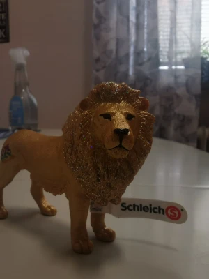 NY Schleich Guldlejon 85 år Jubileum - Limited Edition med TAG - Säljer det exklusiva guldlejonet  som släpptes i begränsad upplaga för att fira Schleichs 85-årsjubileum. Detta är ett samlarobjekt som inte längre tillverkas. ​Helt perfekt skick (MINT). Har bara stått på hylla. ​Detaljer: Originaletiketten (tagen) sitter kvar på benet. Glittret i manen är intakt och färgen har inga skav. Den färgglada "85"- loggan på bakbenet är helt tydlig. ​Kommer från ett rök- och djurfritt hem. ​Ett måste för Schleich-samlaren då det är svårt att hitta i detta med lapp