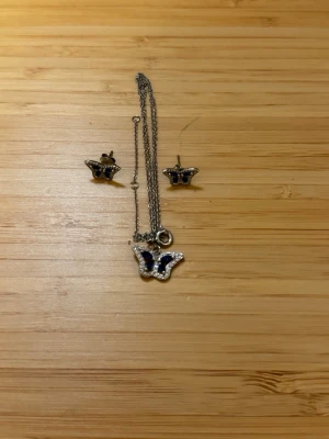 Smyckesset med örhängen och halsband  - Matchande örhängen och halsband med fjärilsform. Aldrig använda, har dock inte originalpaket då jag fick dessa i present något år sedan. 