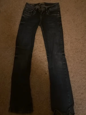Mörkblå bootcut jeans - Säljer ett par mörkblå bootcut jeans med klassisk femficksdesign och låg midja. 