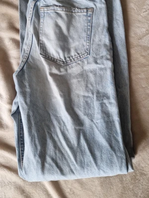 Ljusblå jeans från Gina Tricot - Säljer ett par ljusblå jeans från Gina Tricot i klassisk femficksmodell. Jeansen har raka ben. Bild med jeansen på skickas vid intresse av köp