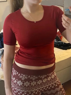 Vinröd croppad t-shirt från oui - Säljer en vinröd croppad t-shirt från oui essentials med rund halsringning och korta ärmar. T-shirten har en slim passform och är gjord i mjukt bomullsmaterial som sitter snyggt på kroppen. Perfekt till jeans eller kjol! Super skön och fin. 