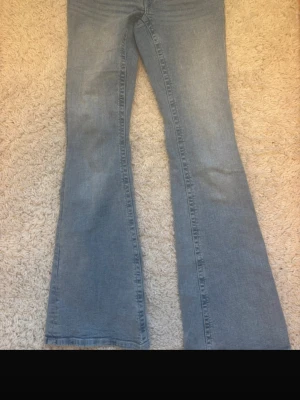 Blå bootcut jeans från Gina Tricot - Jag säljer ett par ljusblå jeans med rosa broderi på fickorna, i storlek S 14+.Har använt några gånger, men dom är en då i bra skick. Köpte dom på Gina tricot men, tror dom har slutat sålt dom.💗💗