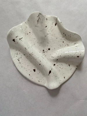 Smyckesförvaring i organisk form - Unikt fat i vit färg med bruna stänk och vågig, organisk form. Perfekta som dekoration eller förvaring av småsaker. Handgjorda och konstnärliga, varje fat har sitt eget uttryck. GÄLLER ENDAST ETT FAT Denna säljs till ett lägre pris då finishen skiljer sig något – men lika fin att använda ✨