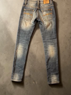 Nudie jeans - Jeans från nudie, storlek W:27 L:33. Jeansen är i mycket gott skick. 75 cm innerbenslängd, 98,5 cm längd, 36 cm tvärs över midjan. Hör gärna av dig vid minsta fundering!