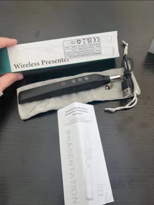 Trådlös presenter fjärrkontroll USB - Säljer en svart trådlös presenter fjärrkontroll med USB-mottagare. Perfekt för presentationer, har flera knappar för att styra slides och laserpekare. Kommer med laddkabel, förvaringspåse och manual. Smidig och lätt att ta med.