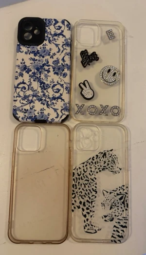 4-pack mobilskal till iPhone 12 - Säljer fyra olika mobilskal till iPhone 12. Ett med blått blommönster, ett transparent med dekorationer som smiley och text osv, ett helt genomskinligt och ett transparent med svartvita leoparder (Alla skal är i plast)