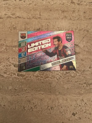 Limited Edition Messi samlarkort - Säljer ett Limited Edition samlarkort från FIFA 365 med motiv av en fotbollsspelare i Barcelona-tröja. Kortet har holografiska detaljer och färger i rosa, silver, grön och svart. Baksidan har en spelplan och en unik kod.