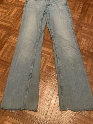 Ljusblåa vida jeans med rå kant - Säljer ett par ljusblå jeans. Har använt några gånger men tycker att den är för hög midjad.
