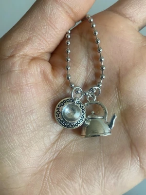 Silverfärgat pärlhalsband - Ett stilrent halsband med små, runda silverfärgade pärlor i hela kedjan. Halsbandet har en enkel och modern design som passar perfekt till olika outfits. Materialet ser ut att vara metall och kedjan är pärlformad.