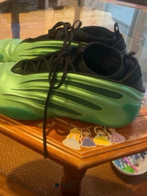 Gröna Adidas harden 9of - Säljer ett par basketskor  med svart ovandel och svarta skosnören. Skorna har en futuristisk design med gröna detaljer och en chunky sula. Perfekta för dig som vill sticka ut med din stil.