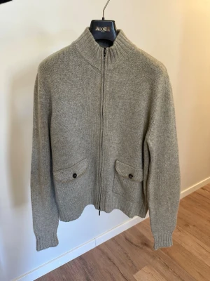 Loro Piana 100% cashmere Cardigan 48 - Otroligt fin cardigan full zip från loro piana i 100% Kashmir. Storlek 48, motsvarar Medium, liten L Toppskick, inga hål eller så, vänster armbågslapp är lite mörkare i mockan  Mocka detaljer på armbågar och vid zip Nypris på runt 35tkr