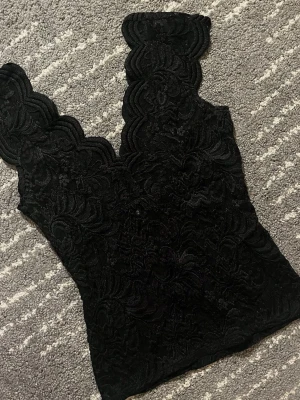 Svart spetstopp från zara - Säljer en svart topp med spets och v-formad urringning från zara. Köpt här på plick men aldrig använd då den är en storlek för stor för mig. 