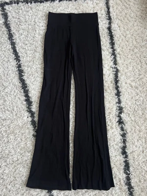 Leggings - Säljer ett par svarta leggings från Alcott med ribbad linning. Modellen har utsvängda ben och är gjorda i ett mjukt, stretchigt material som sitter skönt på kroppen. Storlek S, kanske något mindre i storleken. Uppfattar dom som mid waist. Aldrig använda, endast tvättade 🖤  