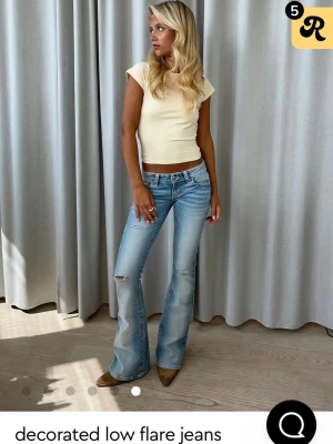 Lågmidjade jeans - Blåa lågmidjade jeans med slitningar från Gina Tricot 14+ storlek XS. Jättefina detaljerade fickor. Finns egna bilder på osv om det önskas 😊