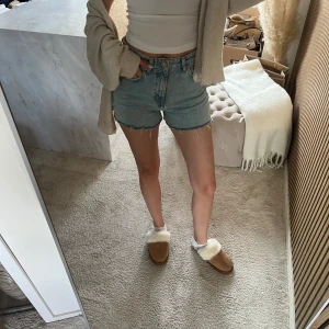 Blå denimshorts från pull&bear - Snygga blå denimshorts med rå, fransad kant och klassisk femficksdesign. Shortsen har normal passform och midwaist. Perfekta för sommaren och lätta att matcha med olika toppar. Inget synligt märke på shortsen.
