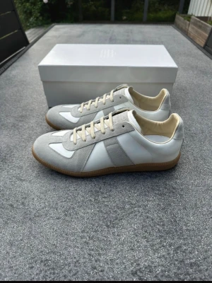 Maison Margiela Gats - Säljer dessa vita maison margiela Gats i storlek 45. Säljs pågrund av att vara för små, de är helt oanvända. Tillkommer box samt dustbag. 