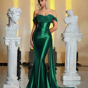 Grön axelbandslös långklänning - Elegant grön axelbandslös långklänning i satin med en smickrande och vacker drapering. Perfekt för en glamorös kväll med en figurnära passform som framhäver kroppen.