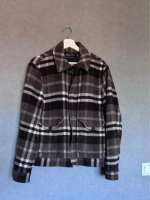 Rutig overshirt från Morris - Snygg overshirt från Morris i brunt, svart och grått rutmönster. Jackan har klassisk krage, dragkedja och två stora fickor med lock och knappar framtill. Perfekt lager-på-lager-plagg i mjukt, tjockt tyg.