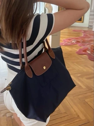Navy longchamp i strl M - Säljer en longchamp vädka i storlek medium i färgen ”navy”. Nypris är cirka 1600kr. Det är inte mina bilder. Den har pytte lite deffekter på undersidan men inget märkvärdigt. Skriv vid frågor🩷