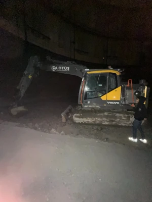 Volvo grävmaskin med larvband - Stor grå och gul grävmaskin från Volvo med larvband och hytt. Maskinen har tydlig Volvo-logga på sidan och robust konstruktion i metall. Perfekt för tunga jobb och entreprenad. Märkt med Lotus på armen.