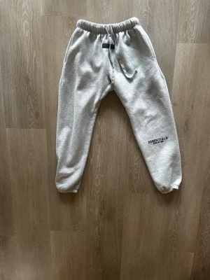 Grå Essentials mjukisbyxor - Grå mjukisbyxor från Essentials. Tillverkade i mjukt material med muddar vid bensluten för en avslappnad och trendig look. ‼️Kan köpas med tröja‼️