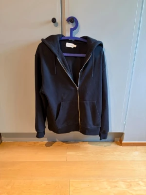 Svart zip-hoodie  - Svart hoodie från Topman med dragkedja framtill och två stora fickor. Storlek S men lite större i storlek så passar M.