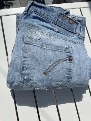 Dondup jeans - Dondup George jeans – en mycket eftertraktad modell från det populära premiumvarumärket Dondup. Jeansen har snygga slitningar och en tvätt som ger den rätta exklusiva och trendiga looken, vilket är en uppskattad detalj och en del av modellens karaktär.  Perfekt passform och hög kvalitet som Dondup är kända för.  Hör gärna av dig vid frågor eller intresse!