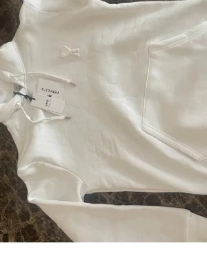 Vit ami Paris hoodie - Helt ny ami Paris hoodie från farfetch, har tagit av lapparna nu, så bilderna är från innan, men helt ny och oanvänd(bara testad). Storlek XL. Passar mig helt okej som är 193, 86kg. Går att få ner den i pris vid snabb affär