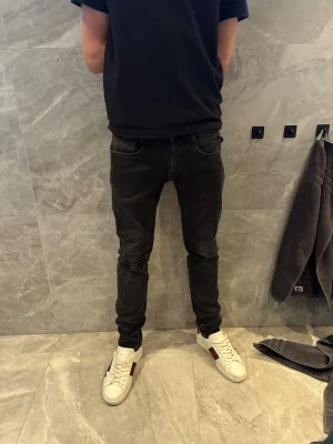 Svarta slim fit jeans - Snygga svarta slim fit jeans med klassisk femficksdesign och smal passform. Jeansen har normal midja och är tillverkade i ett stretchigt material som ger en bekväm känsla. Perfekta för en stilren och modern look.