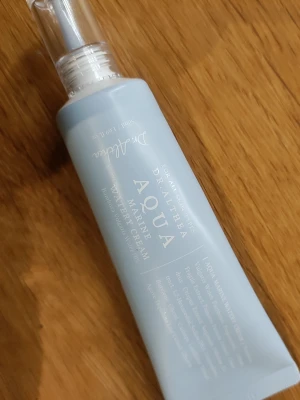 Dr. Althea Aqua Marine Water Cream - Ljusblå tub med genomskinligt lock innehållande Dr. Althea Aqua Marine Water Cream. Tuben är smal och elegant, tillverkad i plast och har vit text. Perfekt för återfuktning och hudvård.