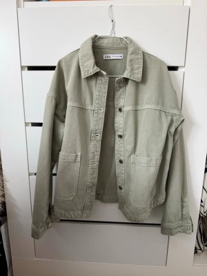 Ljusgrön jeansjacka från ZARA - Jeansjacka i ljusgrönt från ZARA med klassisk krage, stora frontfickor och knäppning framtill. Modellen är något oversized men är i storlek xs. Den är endast använd 1 gång.