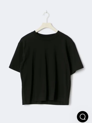 Svart basic t-shirt i bomull - En enkel svart t-shirt med rund hals och korta ärmar. Modellen är rak och något croppad, perfekt för en clean och stilren look. Materialet är mjuk bomull som känns skönt mot huden. Passar dig som gillar minimalistiska plagg.