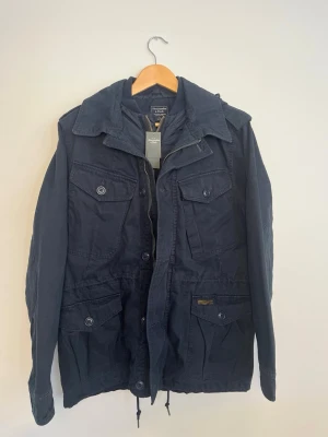 Abercrombie & Fitch Field Jacket  - Tja! Säljer nu denna sjukt feta Field Jacket från Abercrombie & Fitch. Den är helt oanvänd med prislappar kvar! Riktigt snygg som är lätt att styla. Hör av dig om du undrar något! Köpt för 220 €.