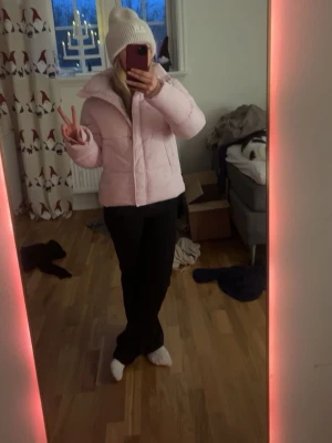 Ljusrosa pufferjacka med huva - Säljer en ljusrosa pufferjacka i st 34 lappen sitter kvar har aldrig använts